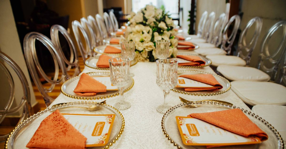 Long dining table arranged for a formal event with elegant decor and place settings.
